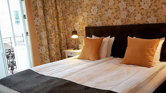 Ett Deluxerum med dubbelsäng och gultapetserad vägg.