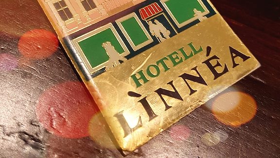 A brass key tag displaying the old hotel entrance.