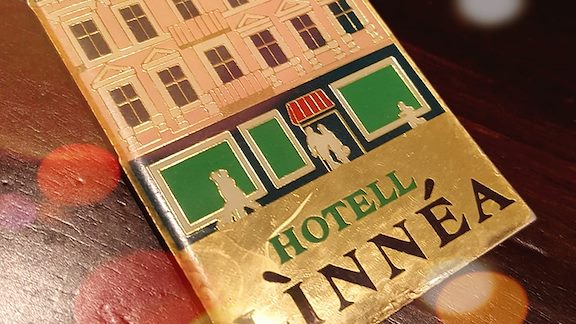 A brass key tag displaying the old hotel entrance.