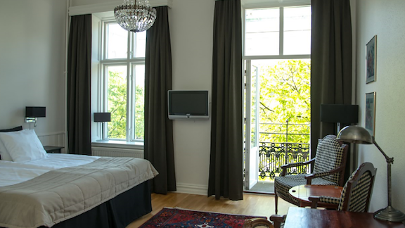 A double bed in a room with a balcony facing the street