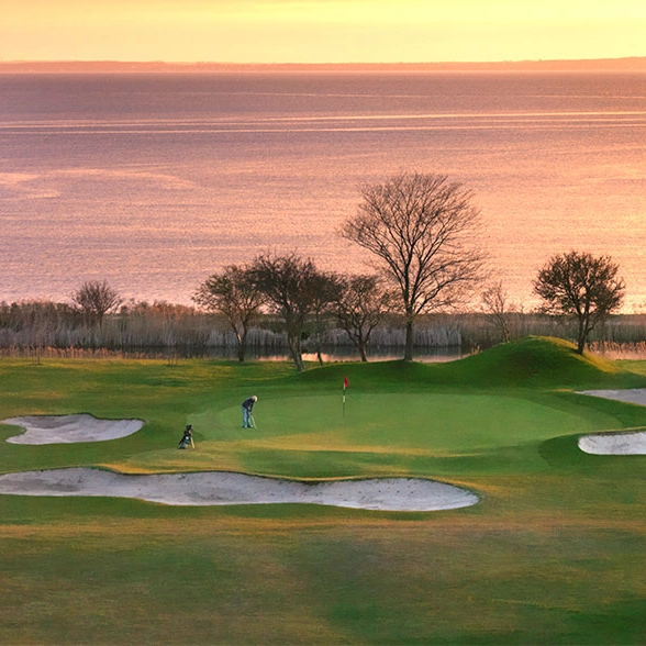 En golfbana vid havet i skymningen.