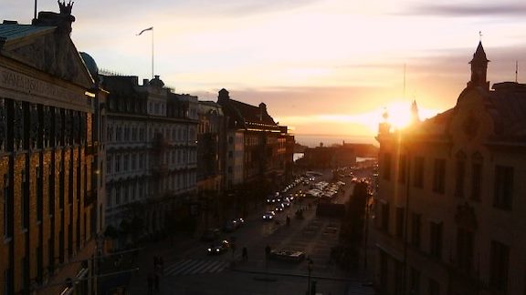 View of Helsingborg`s Stortorget with moving cars in the sunset.
