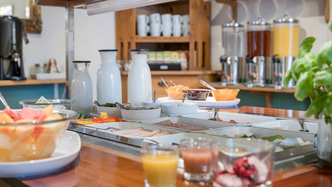 Ett buffébord med olika pålägg, kannor med mjölk och yoghurt, olika typer av sylt och juice.