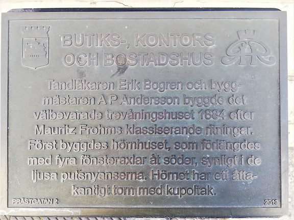 En skylt på information om byggnaden hotellet ligger i, text följer.