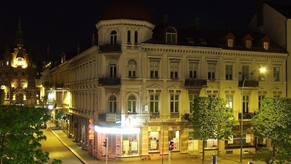 The hotels white corner building on the main street from 1887, during night time.