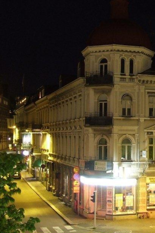 The corner building of the hotel on the main street, during night time.